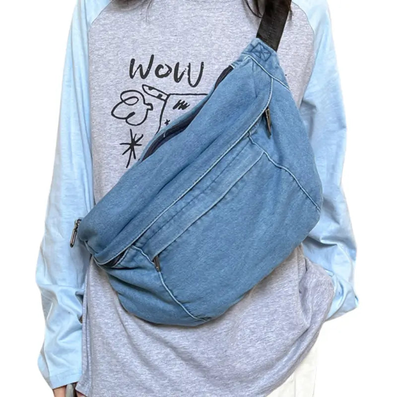 Femme qui porte en bandoulière un grand sac banane en jean bleu clair __switch:Bleu